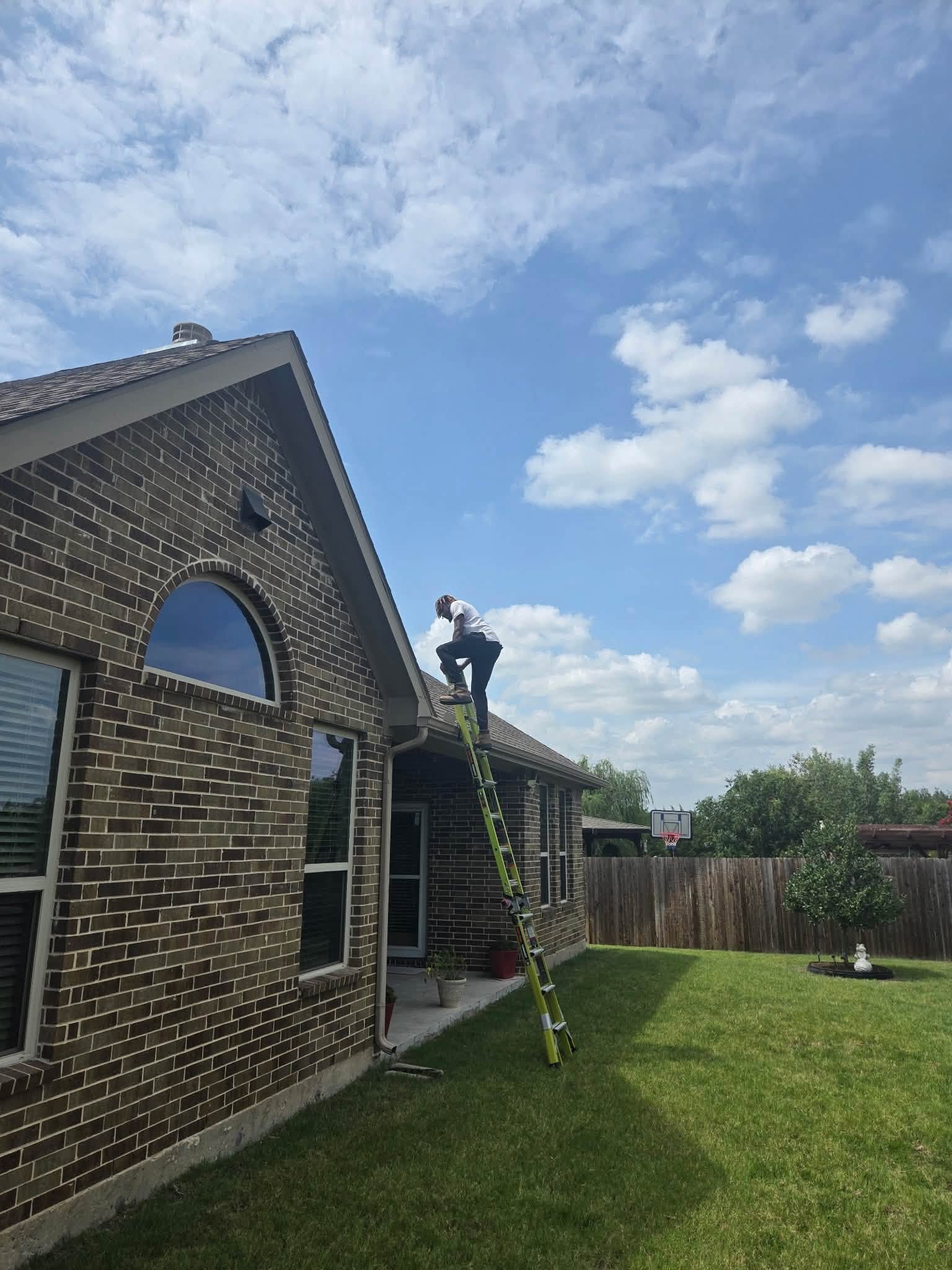 Fireman's Roofing crew member climbing a ladder onto a North Texas roof