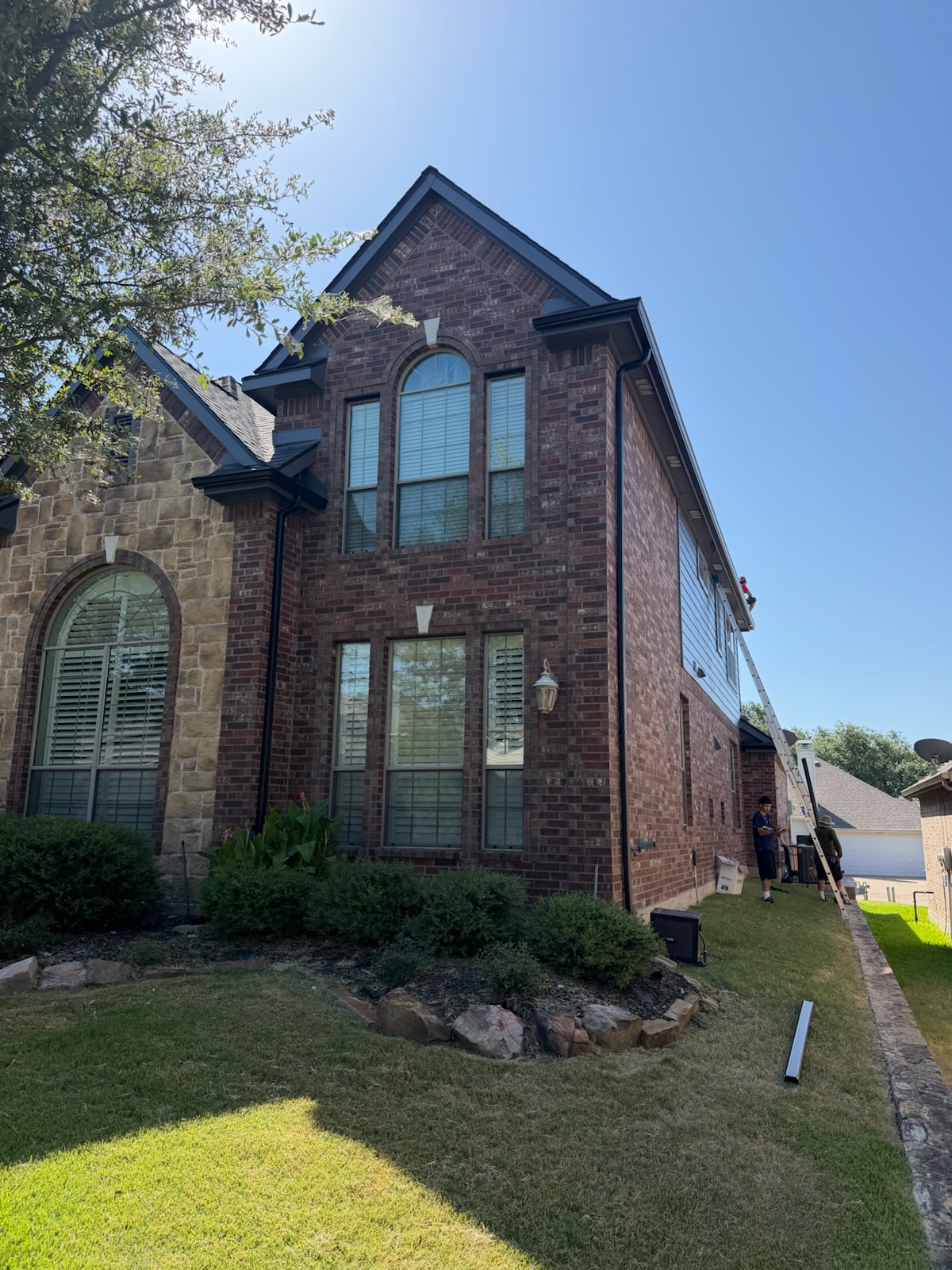 Window installation in progress in McKinney, TX with ladder set against the side elevation
