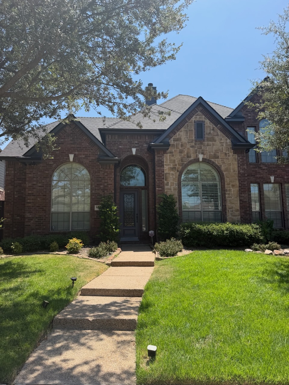 Finished front elevation window replacement with matching arched units on a McKinney, TX home